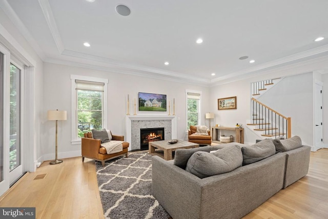 11606 Little Bay Harbor Way, Spotsylvania, VA 22551 - living area with healthy amount of natural light, light wood-style floors, stairs, a glass covered fireplace, and ornamental molding