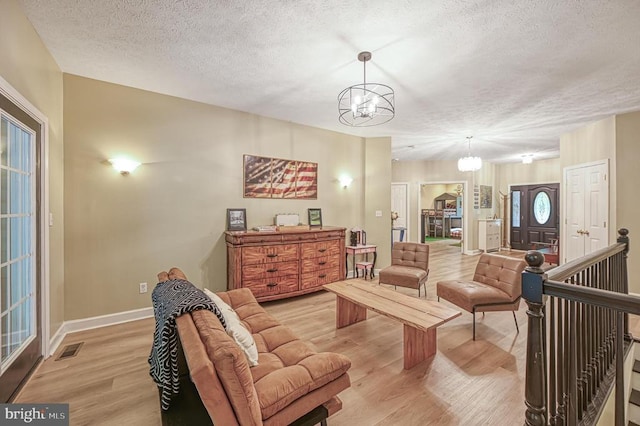 520 Oak Grove Dr, Mineral, VA 23117 - living area with a chandelier, light wood-style flooring, a textured ceiling, and baseboards