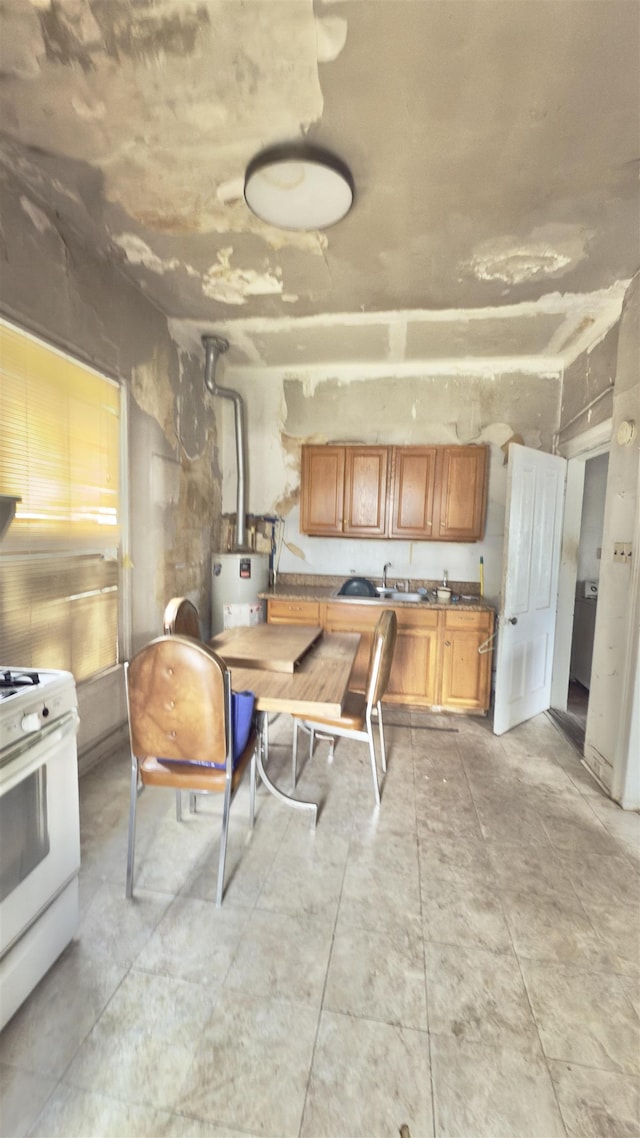 2329 Fort Ave, Lynchburg, VA 24501 - kitchen with white range with gas cooktop, water heater, and brown cabinets