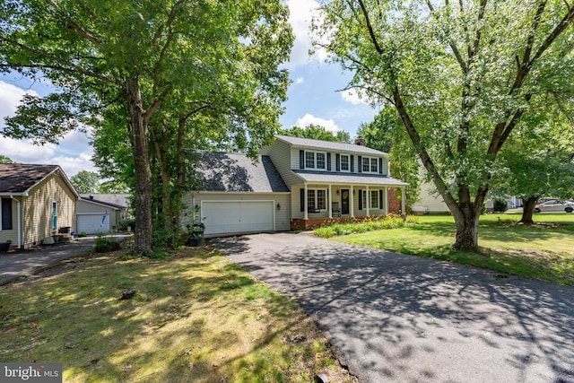 5310 Leavells Crossing Dr, Fredericksburg, VA 22407 - traditional home featuring asphalt driveway, a garage, brick siding, a porch, and a chimney
