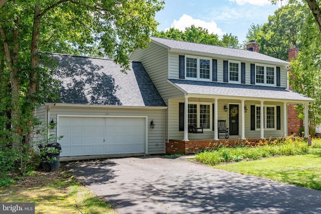5310 Leavells Crossing Dr, Fredericksburg, VA 22407 - view of front of home with a chimney, a porch, an attached garage, asphalt driveway, and a shingled roof