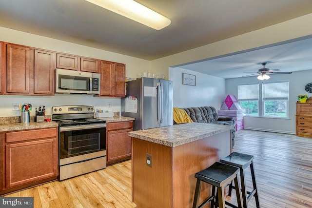 1905 Crepe Myrtle Ln, Culpeper, VA 22701 - kitchen featuring stainless steel appliances, a breakfast bar, light wood-style flooring, open floor plan, and a kitchen island