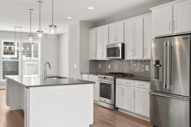 3247 Preston Shore Dr Unit 18D, Rockingham, VA 22801 - kitchen featuring appliances with stainless steel finishes, a sink, decorative backsplash, a center island with sink, and light wood-type flooring
