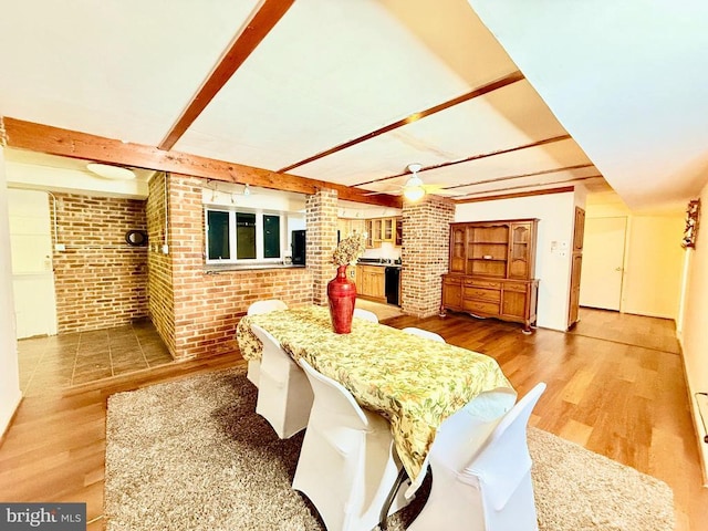 interior space featuring beam ceiling, hardwood / wood-style flooring, and brick wall