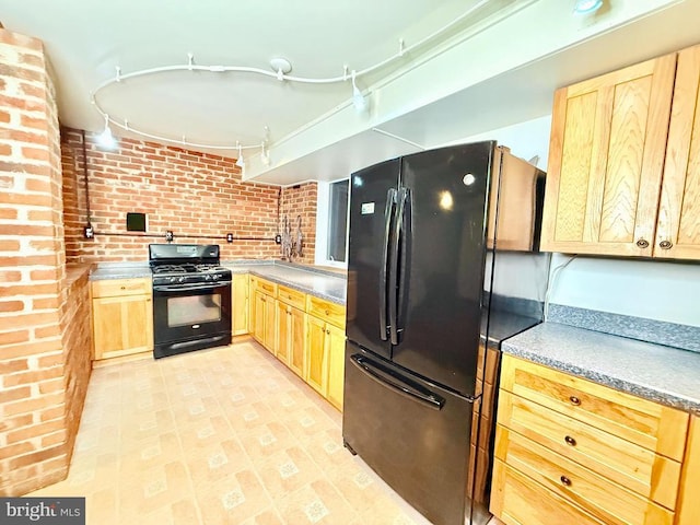 kitchen featuring brick wall, light brown cabinets, and black appliances