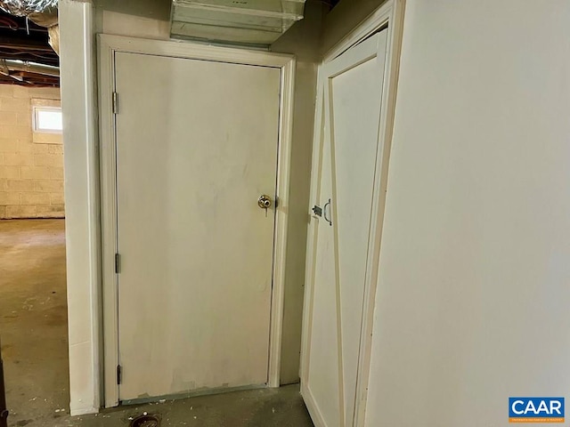 interior space with concrete block wall and unfinished concrete flooring