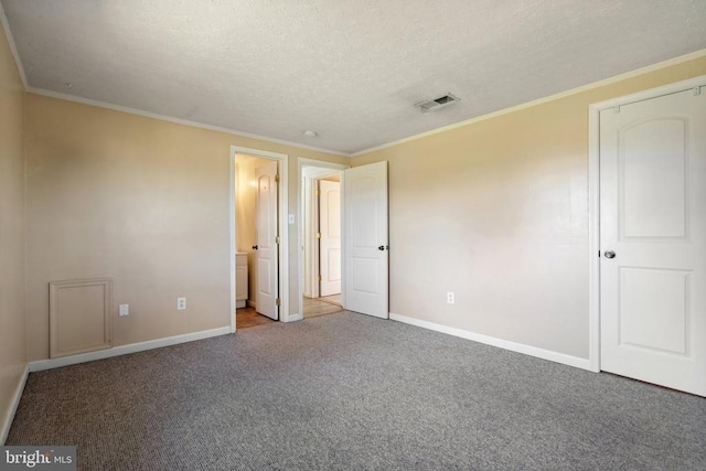 unfurnished bedroom with crown molding, carpet flooring, baseboards, and visible vents
