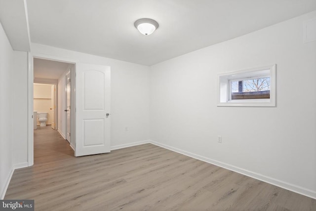 unfurnished room with baseboards and light wood-type flooring