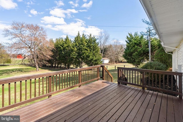 deck featuring a yard, an outdoor structure, and a storage unit