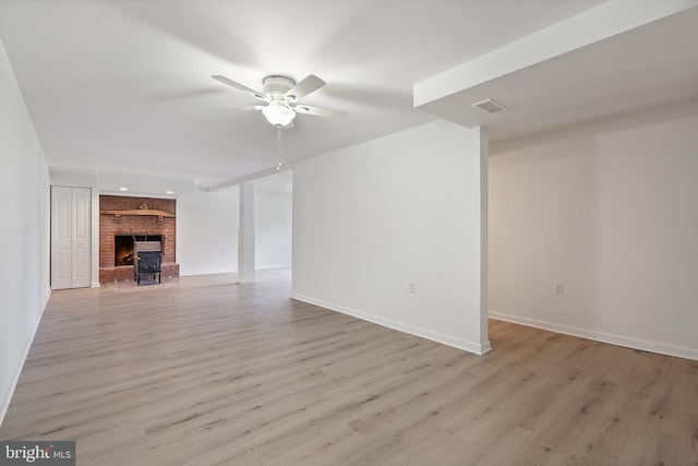 unfurnished living room with visible vents, light wood-style flooring, baseboards, and ceiling fan
