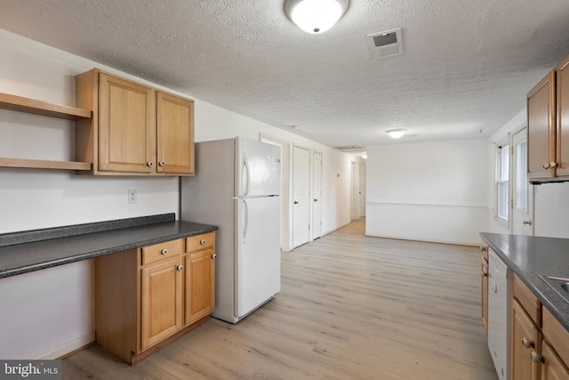 kitchen featuring a textured ceiling, white appliances, dark countertops, and visible vents