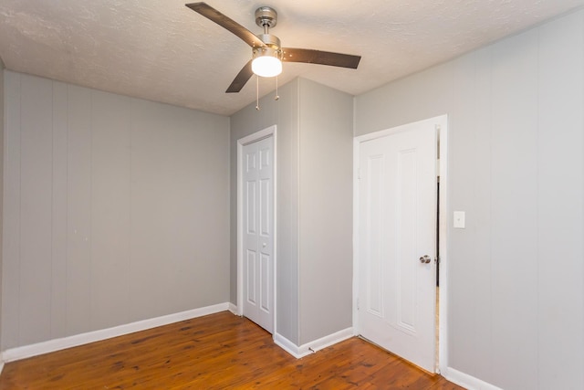 99 Sharp Hill Ln, Hinton, VA 22831 - unfurnished bedroom with wood finished floors, ceiling fan, a textured ceiling, a closet, and a decorative wall