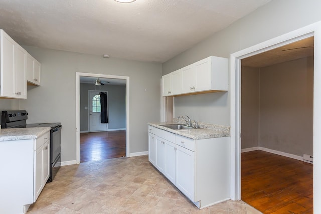 99 Sharp Hill Ln, Hinton, VA 22831 - kitchen with black electric range, light countertops, white cabinetry, light wood finished floors, and a baseboard heating unit