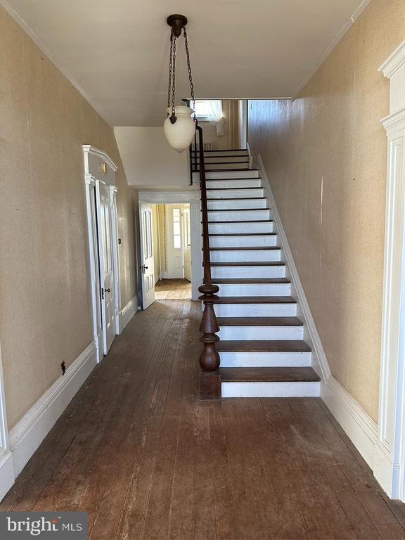 staircase with baseboards and wood-type flooring
