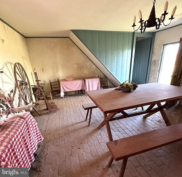 dining area with brick floor and a notable chandelier