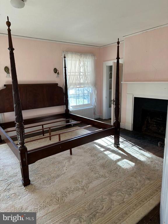 interior space featuring radiator heating unit, a fireplace with flush hearth, and carpet floors