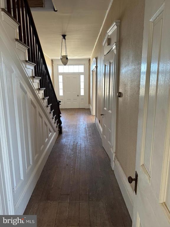 interior space featuring baseboards, stairs, and dark wood-style floors