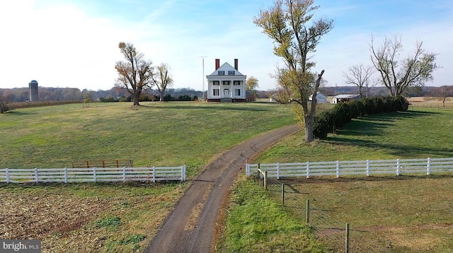 view of yard with fence and a rural view
