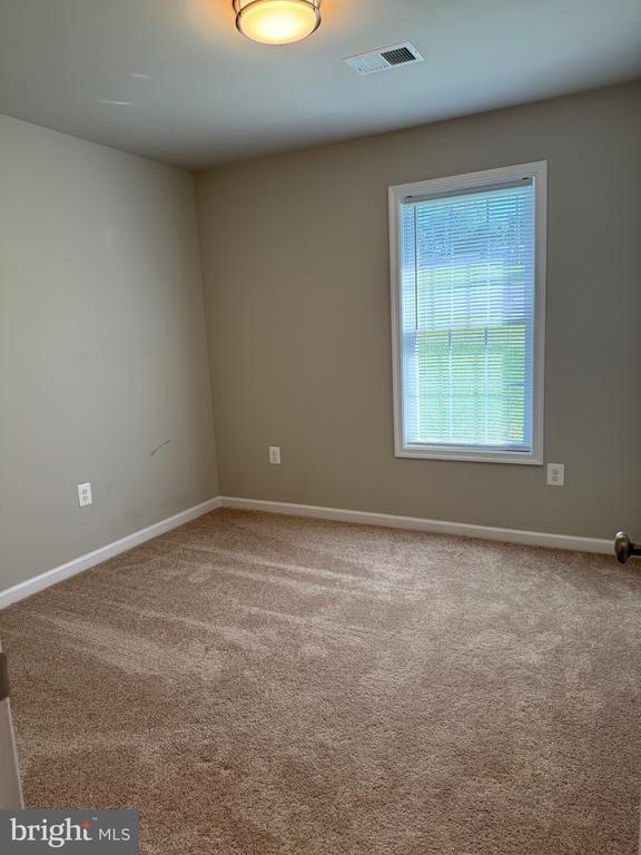 carpeted spare room featuring baseboards