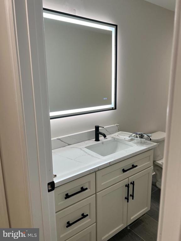 bathroom featuring vanity and toilet
