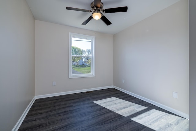 unfurnished room featuring baseboards, dark wood-style floors, and a ceiling fan
