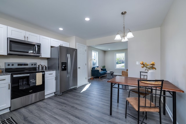 kitchen featuring dark wood-style flooring, a notable chandelier, white cabinets, and appliances with stainless steel finishes