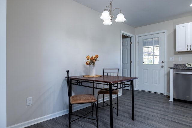 dining area featuring baseboards, a notable chandelier, and dark wood-type flooring