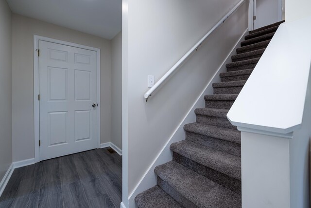 stairway with wood finished floors and baseboards