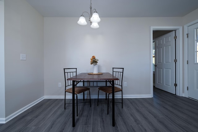 dining space featuring a notable chandelier, baseboards, and dark wood finished floors