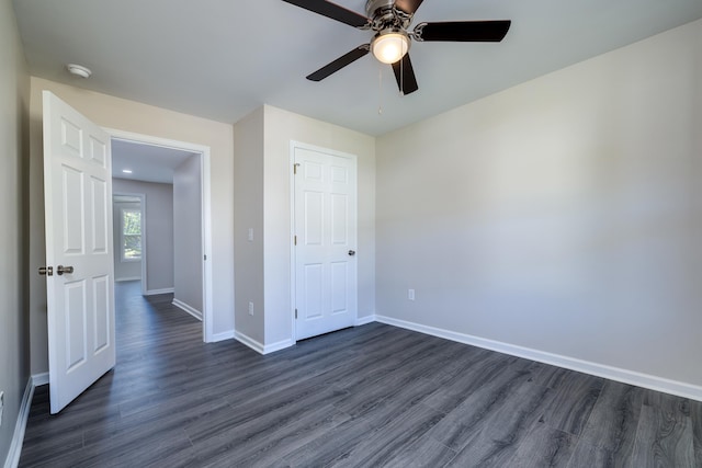 unfurnished bedroom with baseboards, a ceiling fan, and dark wood-style floors