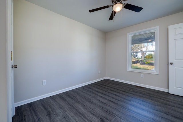 spare room with baseboards, a ceiling fan, visible vents, and dark wood finished floors