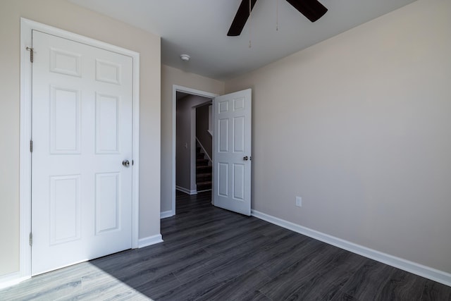 unfurnished bedroom featuring baseboards, ceiling fan, and dark wood-style floors