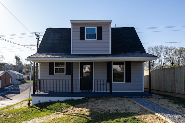 bungalow-style house featuring covered porch, roof with shingles, and fence
