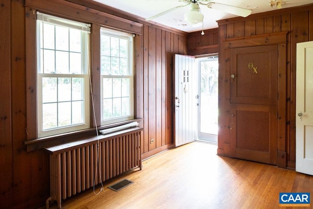 2201 Stadium Rd, Charlottesville, VA 22903 - foyer featuring radiator heating unit, light wood-style floors, wooden walls, and ceiling fan
