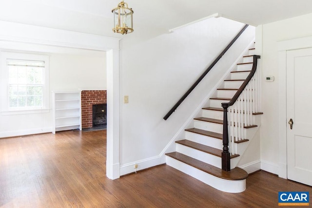 2201 Stadium Rd, Charlottesville, VA 22903 - stairway featuring wood finished floors, a chandelier, and a fireplace