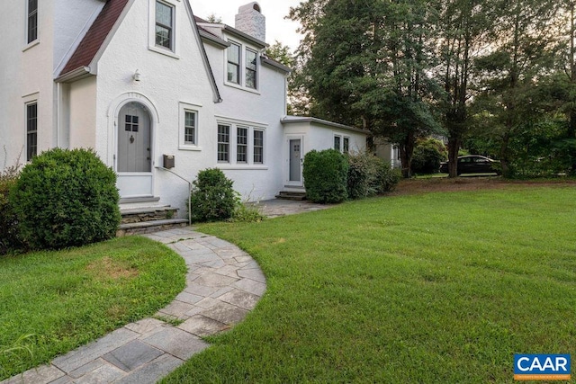 2201 Stadium Rd, Charlottesville, VA 22903 - view of front of house with entry steps, a chimney, a front yard, and stucco siding