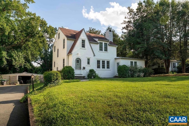 2201 Stadium Rd, Charlottesville, VA 22903 - english style home with a front lawn, a chimney, stucco siding, and a detached carport