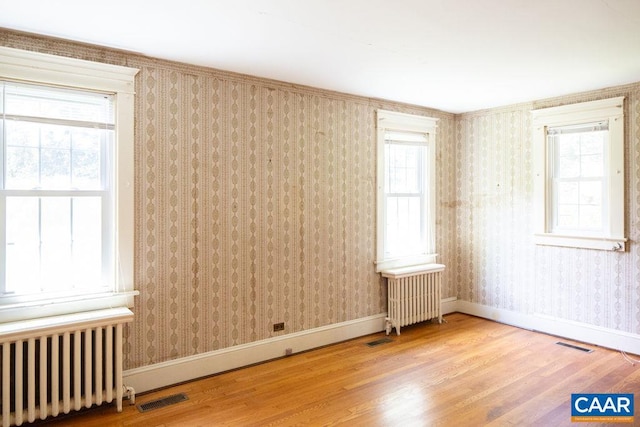 2201 Stadium Rd, Charlottesville, VA 22903 - spare room featuring radiator, wood finished floors, and wallpapered walls