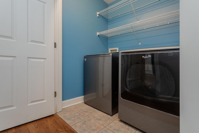 washroom with separate washer and dryer and light tile patterned floors