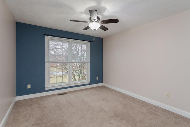 carpeted empty room featuring ceiling fan and a textured ceiling