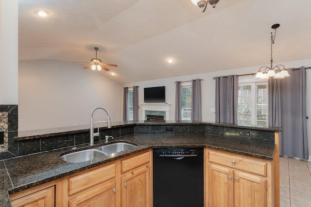 kitchen featuring pendant lighting, lofted ceiling, black dishwasher, sink, and dark stone counters