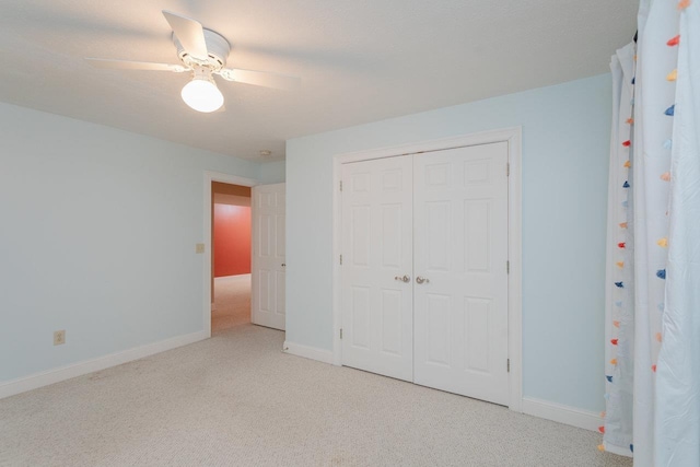 unfurnished bedroom featuring light colored carpet, ceiling fan, and a closet