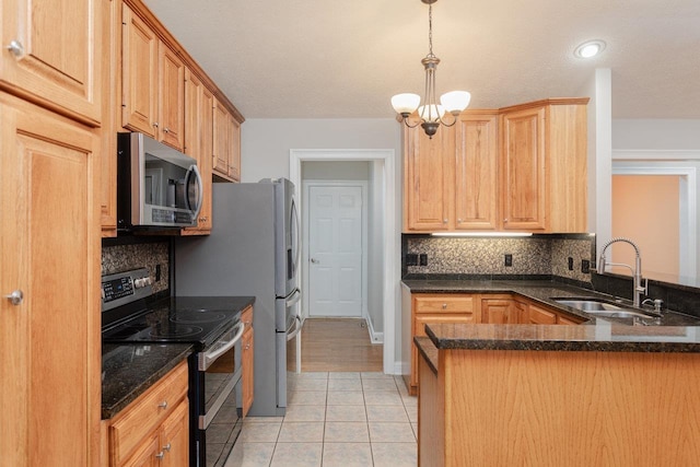 kitchen with light tile patterned flooring, appliances with stainless steel finishes, sink, hanging light fixtures, and kitchen peninsula