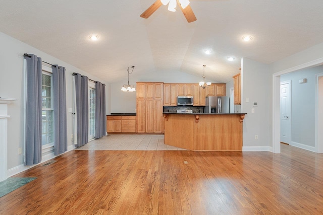 kitchen with a breakfast bar area, appliances with stainless steel finishes, hanging light fixtures, kitchen peninsula, and light wood-type flooring