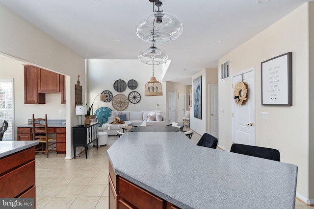 kitchen with light tile patterned floors, hanging light fixtures, light countertops, open floor plan, and recessed lighting