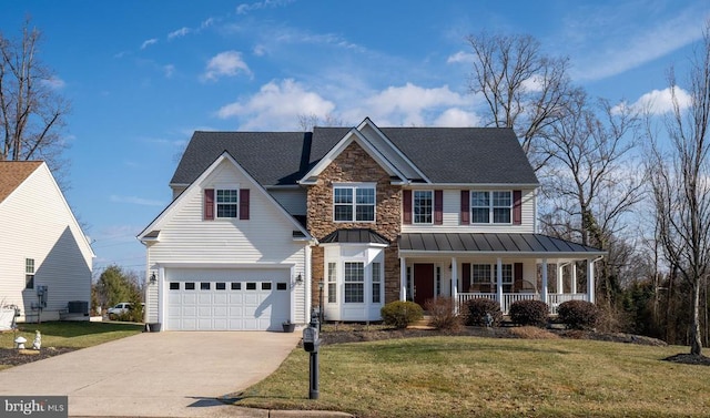 view of front of home with a porch, concrete driveway, a standing seam roof, and a front lawn