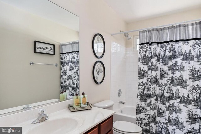 bathroom with toilet, vanity, and shower / tub combo