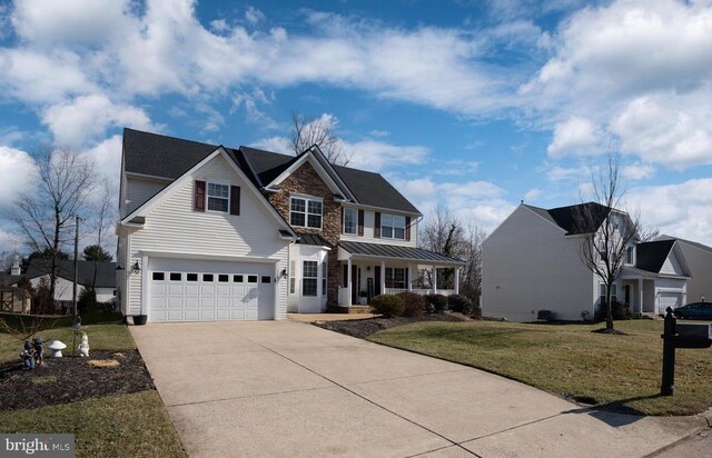 view of front facade featuring a porch, driveway, a garage, a front yard, and a standing seam roof