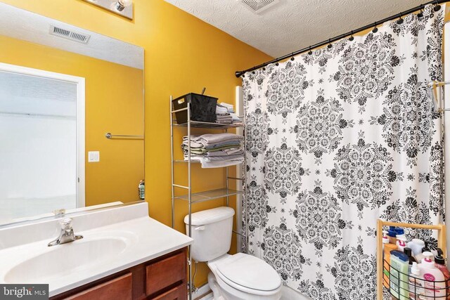 full bath with a textured ceiling, toilet, vanity, and a shower with curtain
