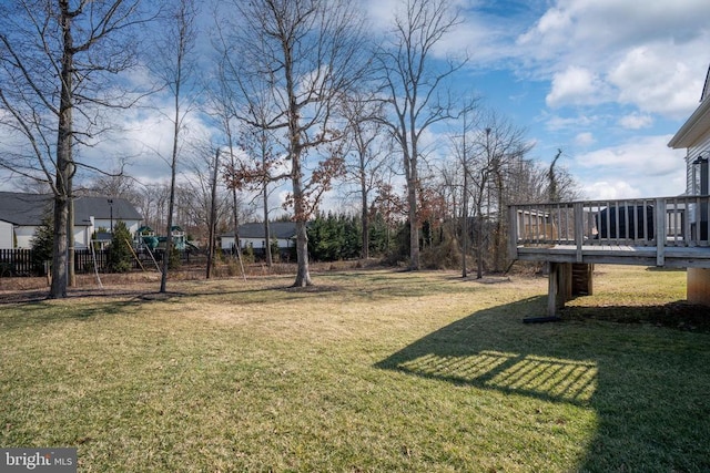 view of green lawn featuring a deck